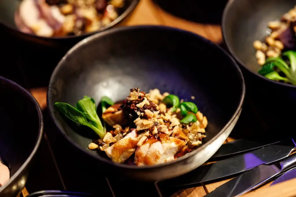 Walking dinner gerecht met kip, noten en veldsla in zwart bord